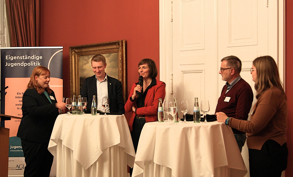 Parlamentarischer Abend: Fünf Podiumsgäste an Stehtischen tauschen sich aus.