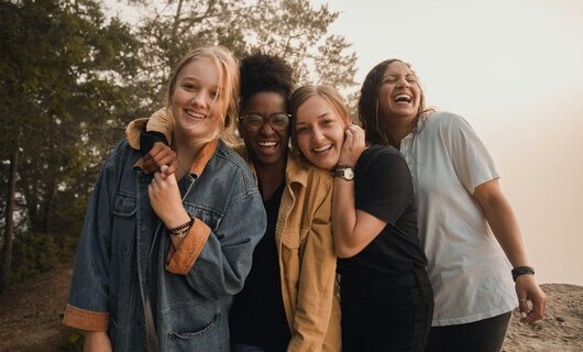 4 junge Menschen stehen dicht zusammen und lachen in die Kamera (Foto: Crosby Hinze via unsplash.com)
