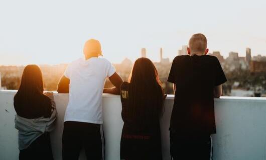 Vier Menschen schauen in den Sonnenuntergang