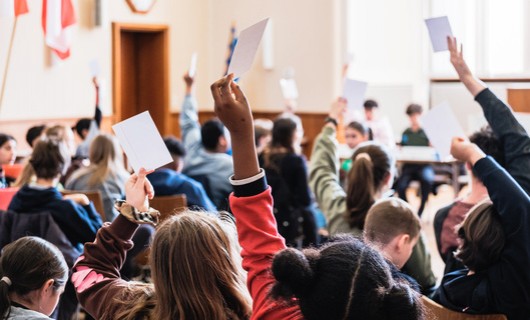 Kinder halten Karten hoch bei einer Abstimmung