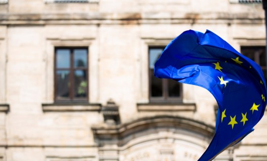 Europaflagge wird geschwenkt vor einem Gebäude