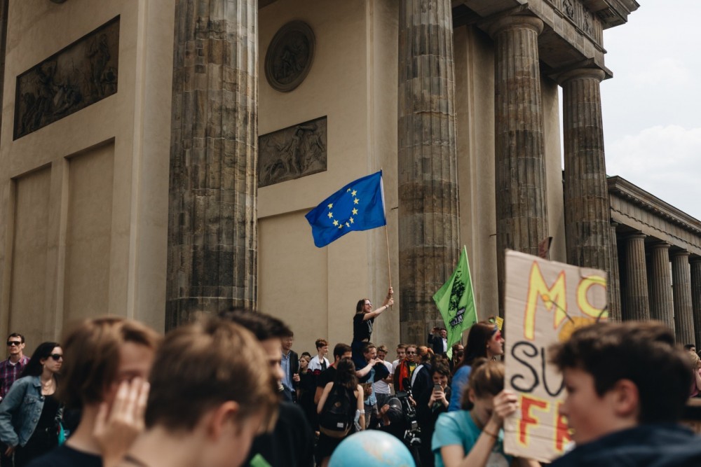 Junge Menschen auf einer Demonstration mit einer Europaflagge.