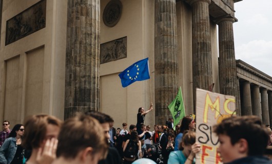 Junge Menschen auf einer Demonstration mit einer Europaflagge.