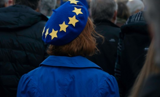 Eine Frau ist von hinten zu sehen, sie trägt eine blaue Mütze mit gelben Sternen.
