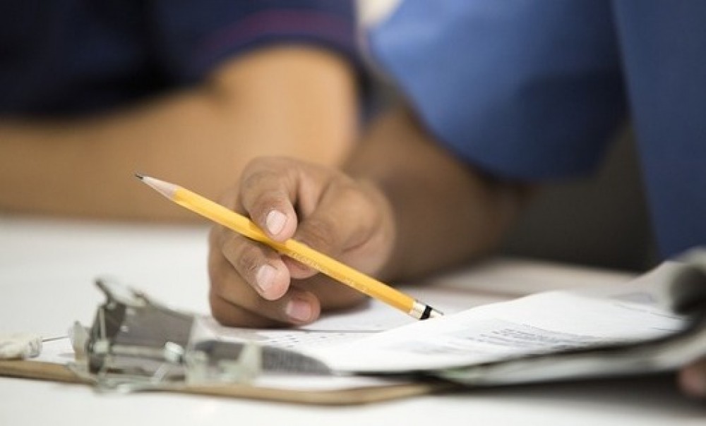 Hand mit Bleistift an Schreibtisch