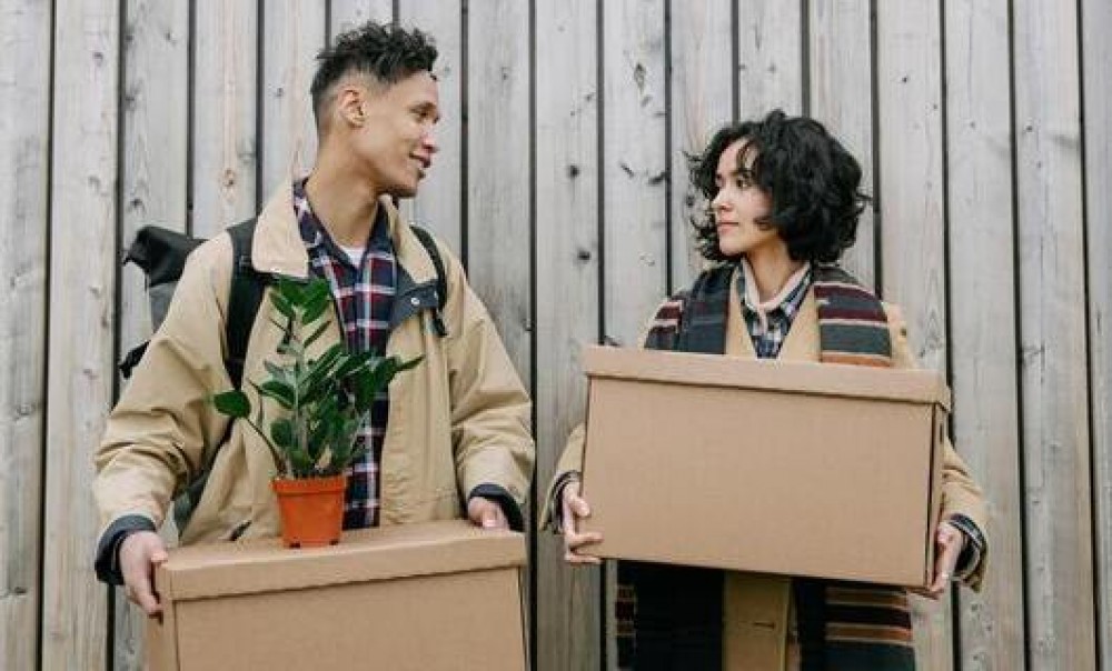 Zwei junge Menschen mit Umzugskartons (Foto: Ivan S via pexels.com)