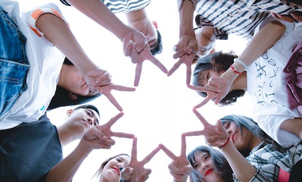 Foto: Junge Menschen halten ihre Finger in Sternform zusammen