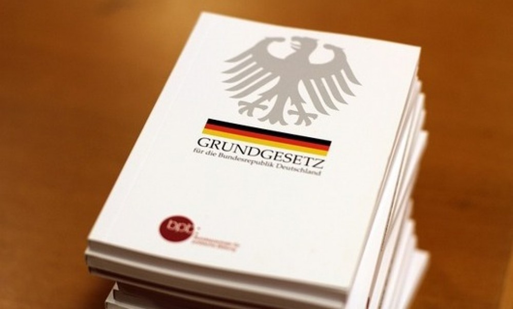 Das Grundgesetz als Buch liegt auf einem Tisch