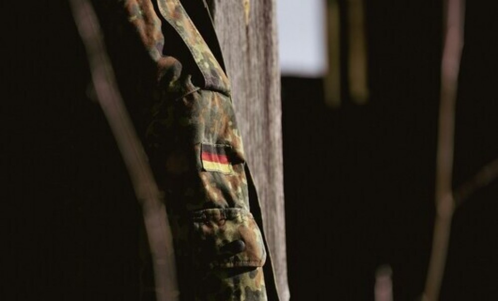 Foto: Touko Aikioniemi via unsplash.com/ Teil einer Bundeswehruniform mit Deutschlandflagge