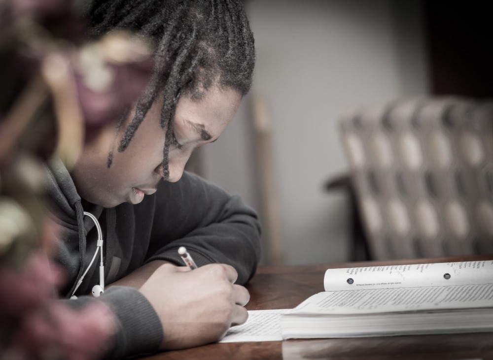 Ein junger Mann macht Hausaufgaben.