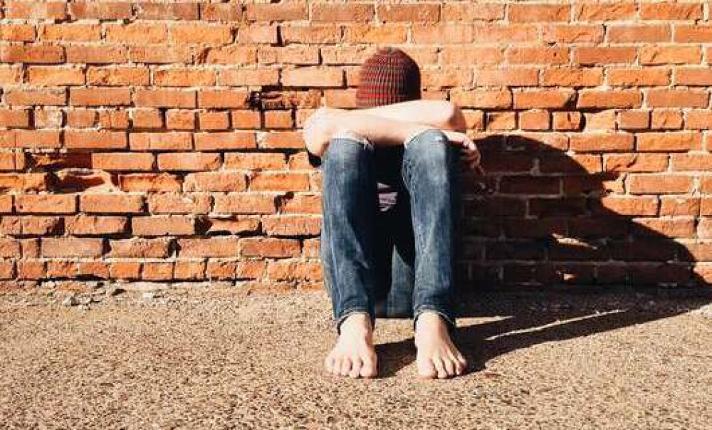 Junge Person sitzt am Boden (Foto: WOKANDAPIX via pixabay.com)